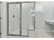 Walk-in shower featuring modern tile, a glass door, a rainfall shower head and a shower bench at 745 Aristocrat Ln, Knightdale, NC 27545