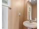 Cozy half bathroom featuring a pedestal sink, peach walls, decorative mirror, and framed artwork at 7838 Spungold St, Raleigh, NC 27617