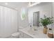 Bright bathroom featuring a shower with a curtain, oval window, vanity and a large mirror at 7838 Spungold St, Raleigh, NC 27617