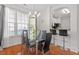 Modern dining area with chandelier, wood floors, and view to a kitchen bar at 7838 Spungold St, Raleigh, NC 27617