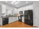 Bright, modern kitchen with white cabinets, stainless steel appliances, and wood floors at 7838 Spungold St, Raleigh, NC 27617