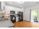 Kitchen with hardwood floors, modern black appliances, plenty of natural light and white cabinets at 7838 Spungold St, Raleigh, NC 27617