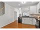 Charming kitchen featuring white cabinets, black appliances, and hardwood flooring with an arched passthrough at 7838 Spungold St, Raleigh, NC 27617