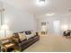 Comfortable living room features neutral carpet, large leather sofa, and ample natural light at 7838 Spungold St, Raleigh, NC 27617