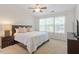 Bright main bedroom with a ceiling fan, large windows, and a plush king-sized bed at 7838 Spungold St, Raleigh, NC 27617