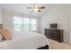 Spacious main bedroom featuring a ceiling fan, dresser, and ample natural light from large windows at 7838 Spungold St, Raleigh, NC 27617