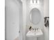 Cozy powder room with white pedestal sink, oval mirror, and stylish fixtures at 8724 Wardle Ct, Wake Forest, NC 27587