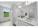 Bathroom featuring double sinks, bright lighting and large mirror at 8724 Wardle Ct, Wake Forest, NC 27587