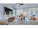 Bright living room featuring neutral furniture, a ceiling fan, and large windows offering plenty of natural light at 8724 Wardle Ct, Wake Forest, NC 27587