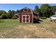 Red outbuilding with a window and double doors set in a manicured lawn and yard at 901 Vandora Ave, Garner, NC 27529