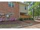 View of the side of the townhouse, showcasing brickwork and vibrant landscaping with flowering bushes at 497 Summerwalk Cir # 497, Chapel Hill, NC 27517