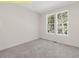 Bedroom featuring neutral carpet and two windows providing natural light and backyard views at 95 Autumnwood Ln, Spring Hope, NC 27882