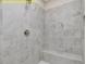 Close-up of the walk-in shower featuring gray tiling and a built-in bench at 95 Autumnwood Ln, Spring Hope, NC 27882