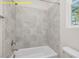 Bathroom with tiled shower, standard shower head, and window view of the landscape at 95 Autumnwood Ln, Spring Hope, NC 27882