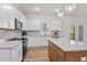 Modern kitchen with white cabinets, stainless appliances, granite counters, and a kitchen island at 95 Leisure Ln # 9, Louisburg, NC 27549