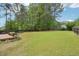 Large backyard with expansive green lawn and a border of trees and shrubs at 100 Winterberry Ln, Holly Springs, NC 27540