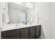 Bathroom featuring a double sink vanity, framed mirror, white walls, and wood-look flooring at 100 Winterberry Ln, Holly Springs, NC 27540