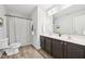 Bathroom featuring a double sink vanity, framed mirror, shower with curtain, and wood-look flooring at 100 Winterberry Ln, Holly Springs, NC 27540