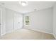 Bright bedroom featuring neutral carpet, double doors, and a scenic window view at 100 Winterberry Ln, Holly Springs, NC 27540