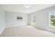 Bedroom featuring carpeted floors, light gray walls, and windows with views of the neighborhood at 100 Winterberry Ln, Holly Springs, NC 27540