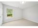 Bedroom featuring neutral carpet, window, and view of the backyard at 100 Winterberry Ln, Holly Springs, NC 27540