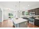 Kitchen features stainless appliances, island seating, and sliding door access to deck at 100 Winterberry Ln, Holly Springs, NC 27540