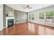 Bright living room with hardwood floors, a modern fireplace, and large windows offering natural light at 100 Winterberry Ln, Holly Springs, NC 27540