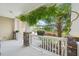 Cozy front porch with white railings, stone columns, and lush greenery, offering a relaxing outdoor space at 100 Winterberry Ln, Holly Springs, NC 27540