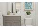 Modern bathroom featuring a vanity with storage, stylish mirror, and decorative plant at 1012 Red Roses Ave, Durham, NC 27703