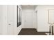 Bright hallway featuring modern art and white doors leading to different areas of the home at 1012 Red Roses Ave, Durham, NC 27703