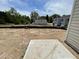 A spacious backyard showing a concrete slab with surrounding green spaces and neighboring houses at 1031 Mountain Crown St, Durham, NC 27703