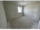 A neutral bedroom with a concrete floor, white walls, and a window at 1031 Mountain Crown St, Durham, NC 27703