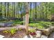 Backyard garden featuring stone retaining walls, colorful flowers, and a wooden arbor at 10609 Lowery Dr, Raleigh, NC 27615