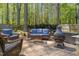 Cozy backyard patio with wicker seating, a small table, a chiminea, and mature trees at 10609 Lowery Dr, Raleigh, NC 27615