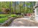 Backyard brick patio and stone retaining wall, complete with outdoor seating and a grill area at 10609 Lowery Dr, Raleigh, NC 27615