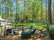 Backyard view with a grill, outdoor seating, and a mature yard with lots of trees at 10609 Lowery Dr, Raleigh, NC 27615
