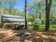 Backyard view of the house with a shed and a fire pit in a yard with mature trees at 10609 Lowery Dr, Raleigh, NC 27615