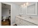 Bright bathroom with double vanity, granite counters, and white cabinetry at 10609 Lowery Dr, Raleigh, NC 27615