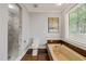 Bathroom with a tiled shower, deep soaking tub, wood accents, and natural light at 10609 Lowery Dr, Raleigh, NC 27615