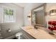 Bathroom with granite countertop, vanity, stylish mirror, and natural light from the window at 10609 Lowery Dr, Raleigh, NC 27615
