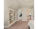 Bright bedroom with custom built-in shelving, neutral walls, and plush carpet, connecting to additional rooms at 10609 Lowery Dr, Raleigh, NC 27615