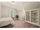 Cozy bedroom featuring built-in shelving, natural light from window, and neutral carpet, offering a tranquil retreat at 10609 Lowery Dr, Raleigh, NC 27615