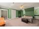 Bright bedroom featuring unique green walls, ceiling fan, carpet, and ample natural light from multiple windows at 10609 Lowery Dr, Raleigh, NC 27615