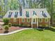 Charming brick home featuring dormer windows, a landscaped yard, and a welcoming front entrance at 10609 Lowery Dr, Raleigh, NC 27615