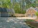 Detached garage and a brick garage with three bays are accessible via a large concrete driveway at 10609 Lowery Dr, Raleigh, NC 27615