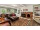 Inviting living room with a brick fireplace, built-in shelving, and green accent walls at 10609 Lowery Dr, Raleigh, NC 27615