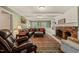 Bright living room featuring a brick fireplace, neutral paint, and large area rug at 10609 Lowery Dr, Raleigh, NC 27615