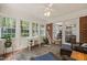 A sunroom with brick flooring, exposed brick wall, lots of windows and wicker furniture at 10609 Lowery Dr, Raleigh, NC 27615