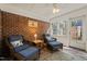 Inviting sunroom with brick walls and floor, wicker furniture, and ample natural light create a cozy retreat at 10609 Lowery Dr, Raleigh, NC 27615
