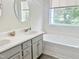 Bright bathroom features a double vanity and soaking tub beneath a window at 10943 Pendragon Pl, Raleigh, NC 27614